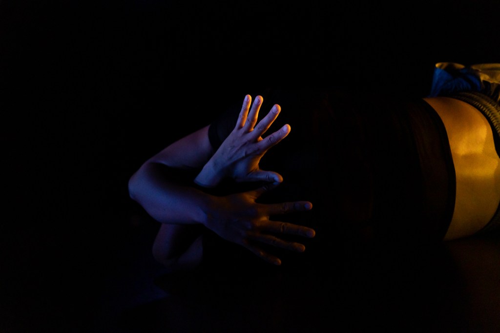hands crossed over torso in shadow