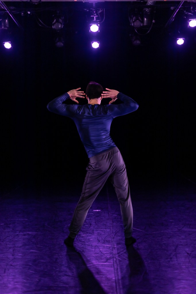 dancer facing upstage hip popped hands on head