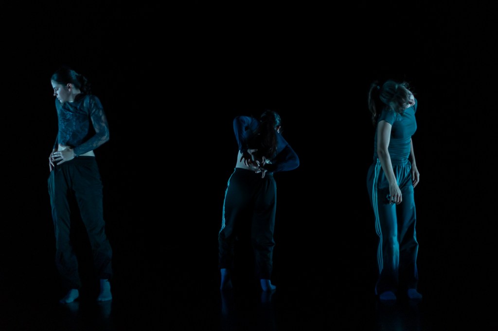 three dancers in moody lighting