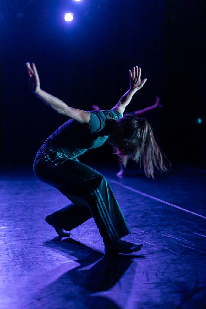 dancer in lunge with arms spread wide head bowed